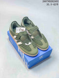Pair of olive-green adidas Samba-style sneakers with crochet-style panels, white stripes, hook-and-loop straps and gum-colored soles