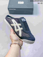 Black and white Onitsuka Tiger Mexico 66 Sabot slip-on sneaker with contrasting side stripes and textured outsole.